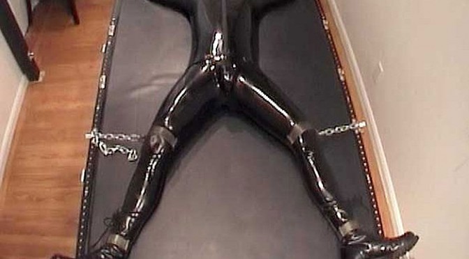 A rubber dude gets bolted down with chains and padlocks