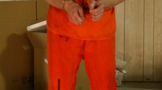Marknorth in prison jumpsuit and chains