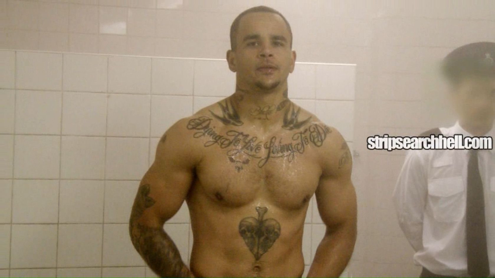 A muscular, tattooed prisoner gets strip-searched