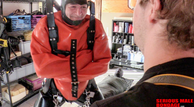 Eckie hangs in an orange rubber straitjacket