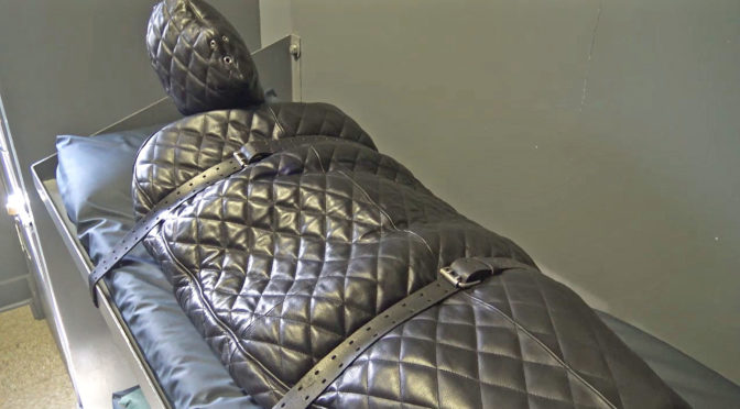 man encased n head to toed leather bondage suit in harsh captivity