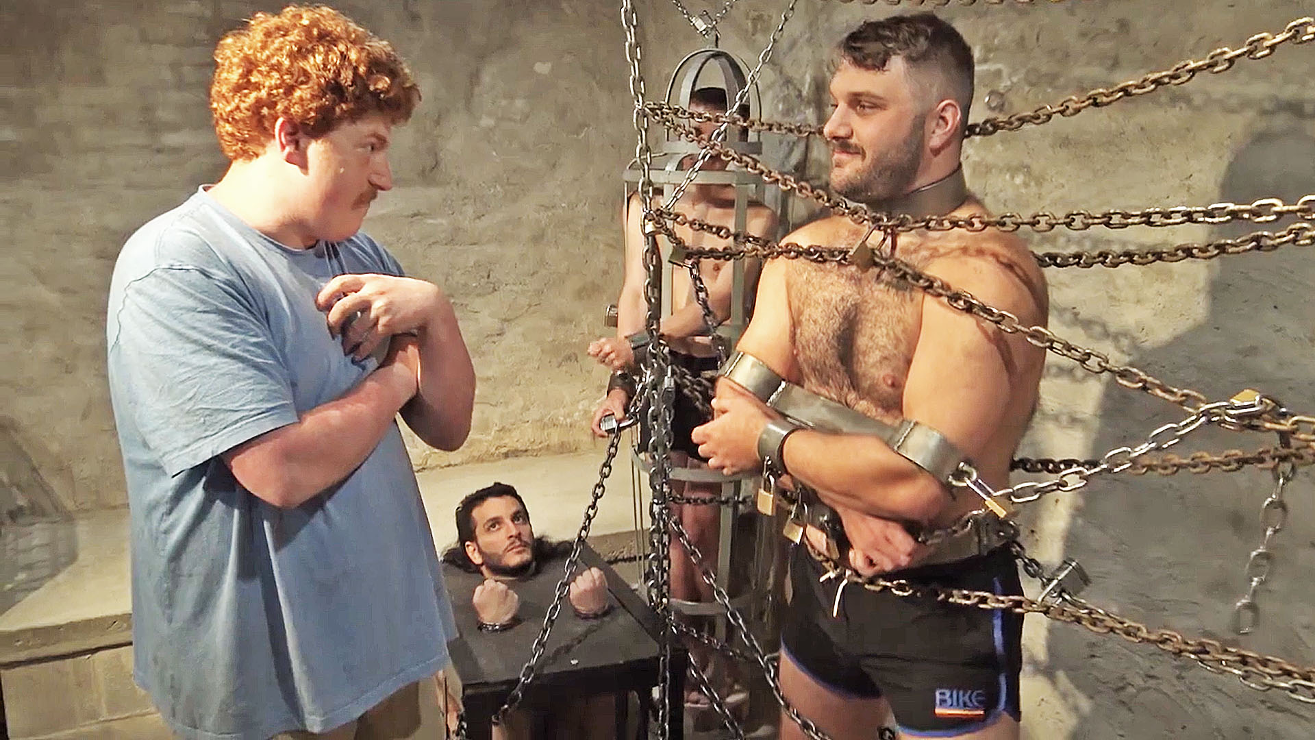 several men are chained inescapably in a dungeon