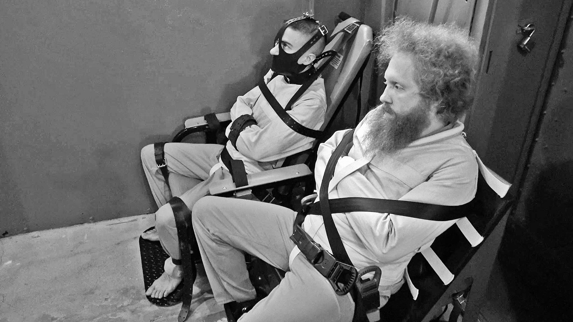 men bound in police restraint chairs and straitjackets
