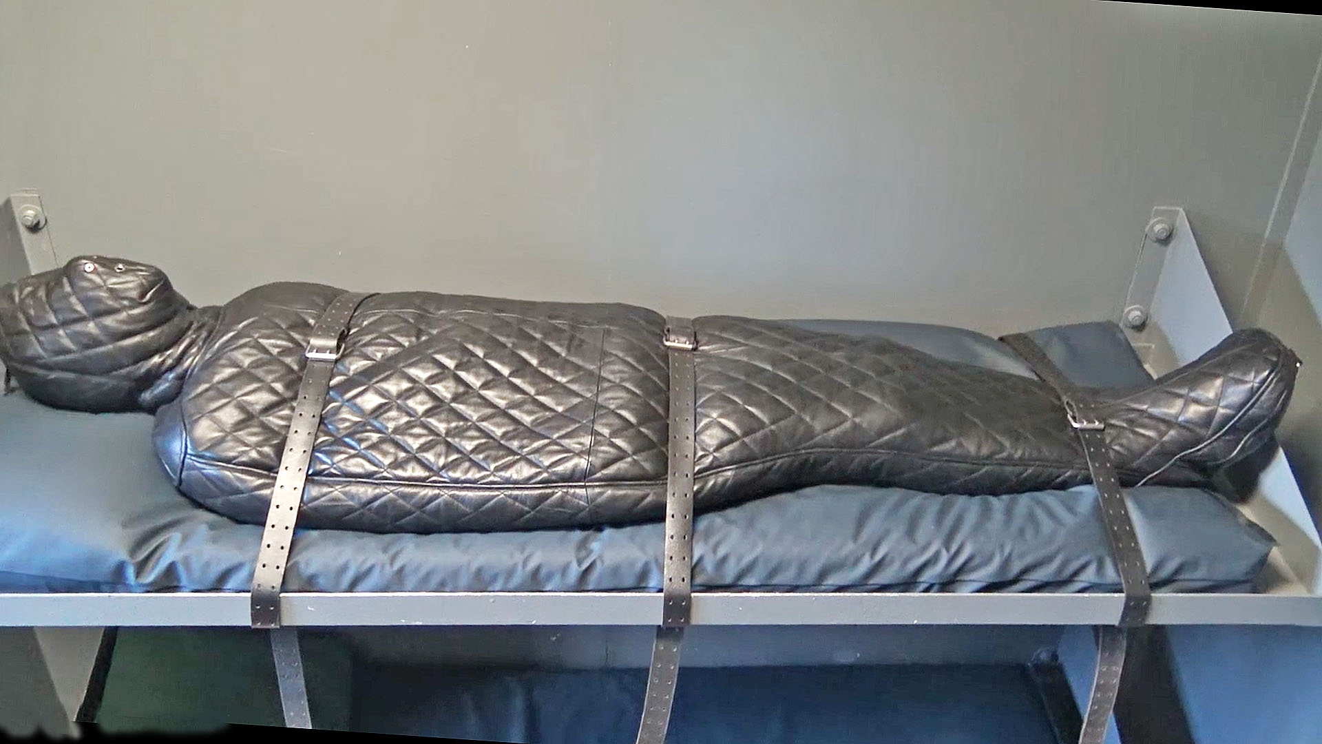 male captive encased in a leather body suit