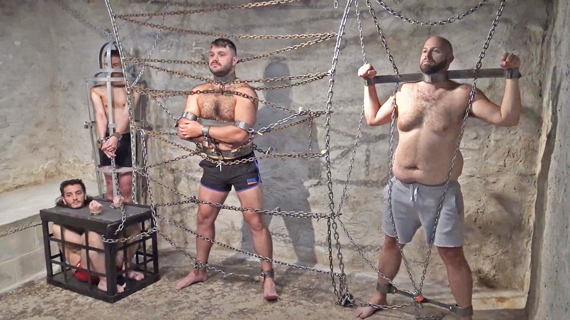 several men are chained inescapably in a dungeon