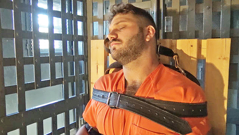 Hooded and strapped inescapably in a bondage chair