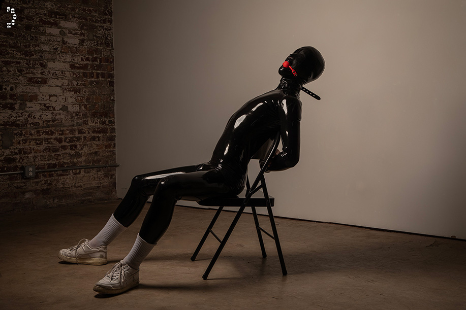 The Rubberhood (he/Him) is covered in full black latex
