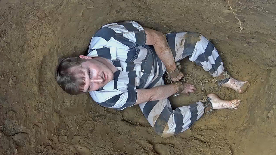 man gets chained up in the dirt