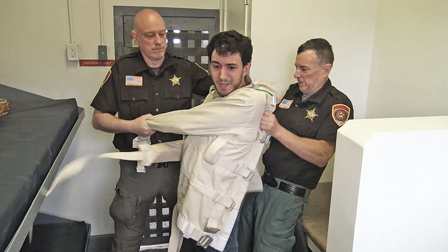 male bondage in a straitjacket and jail cell